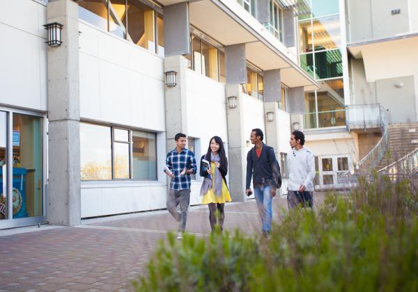 Smiling students walking outside. 