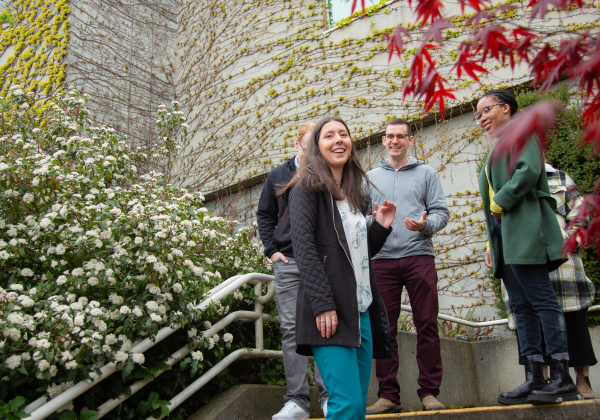 A group of young people on a staircase surrounded by foliage